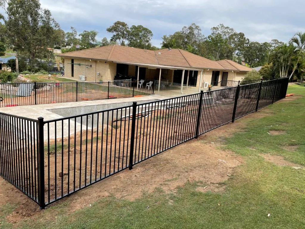 Long run of black aluminium pool fencing on a large residential block