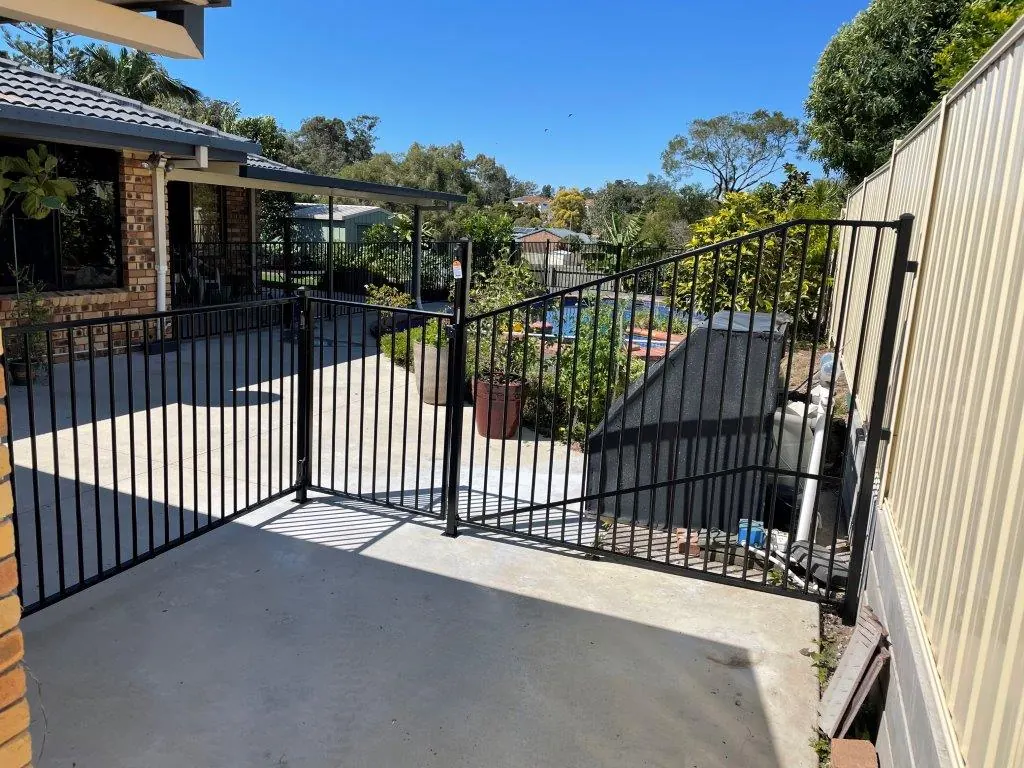 Black aluminium pool fence and gate off a backyard patio
