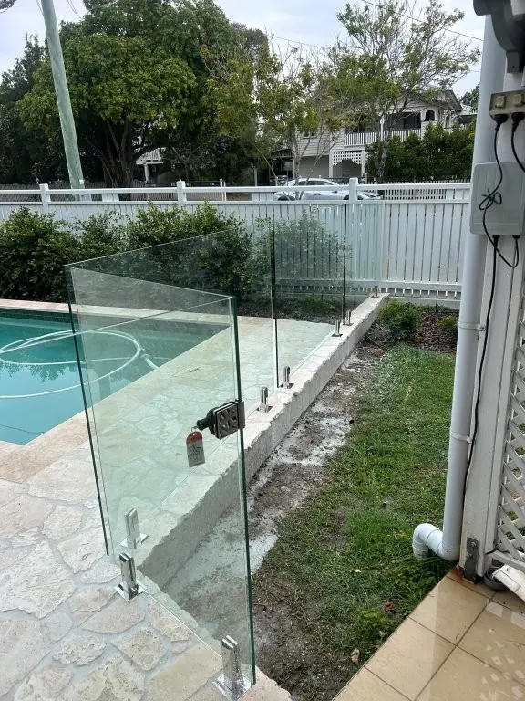 Frameless glass pool gate with a polished self-closing latch